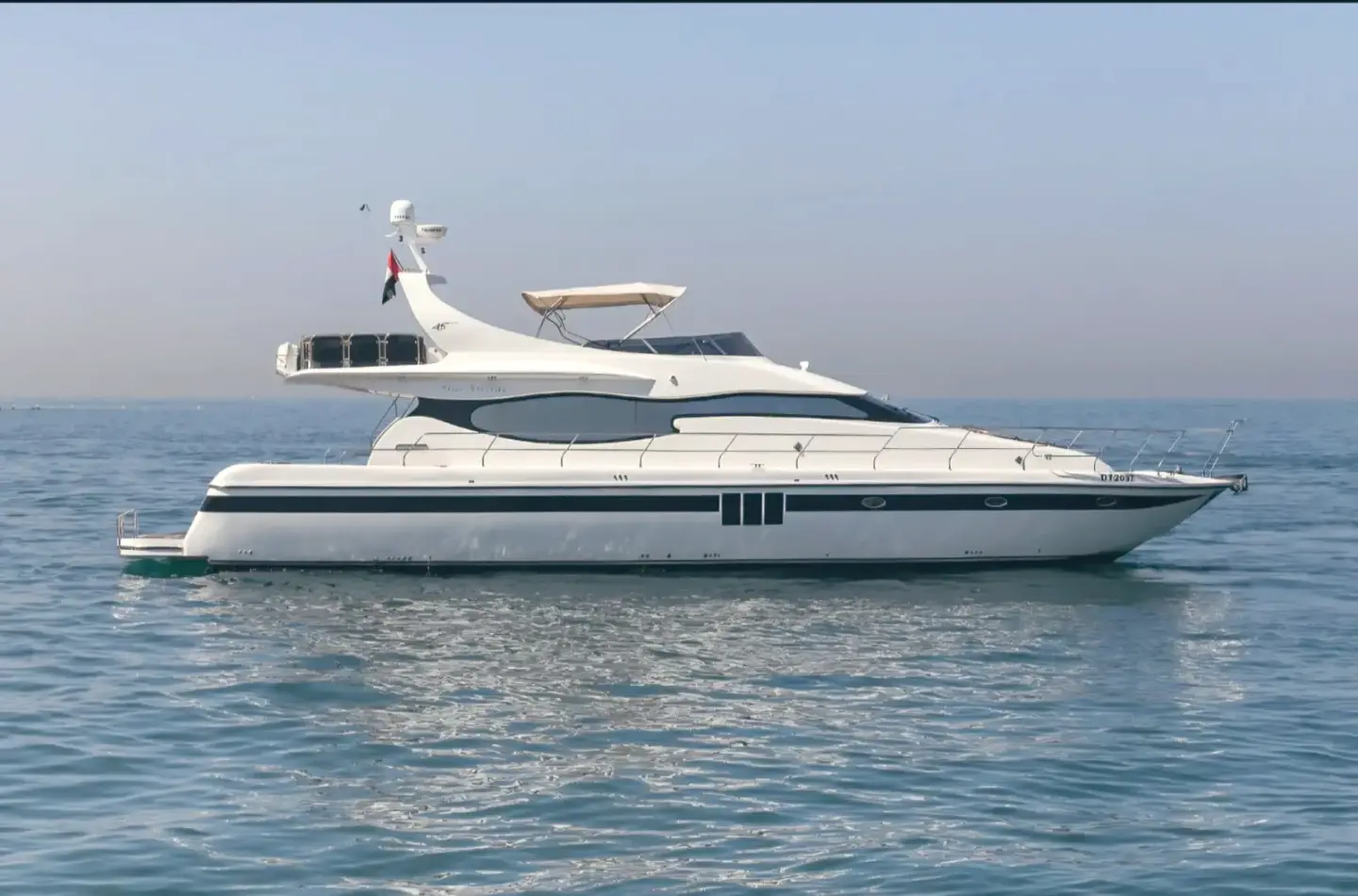 White motor yacht at rest on a calm, light blue sea